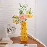 Smiling faces ceramic vase with artificial flowers