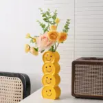 Smiling faces ceramic vase with artificial flowers