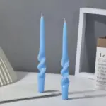 Two pastel coloured household candles