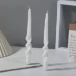 Two pastel coloured household candles