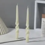 Two pastel coloured household candles