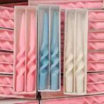 Two pastel coloured household candles