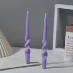 Two pastel coloured household candles