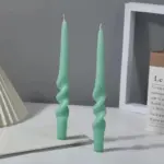 Two pastel coloured household candles