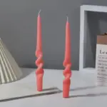 Two pastel coloured household candles